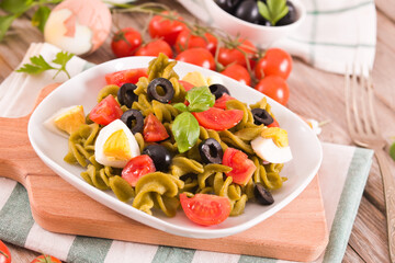 Fusilli pasta with cherry tomatoes, eggs and black olives.
