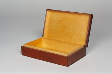 a decorative wooden box with the lid open on a soft gray background with copy space