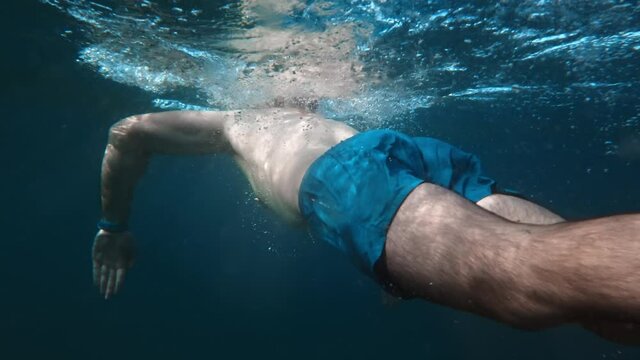Giovane ragazzo nuota a rana nel mare