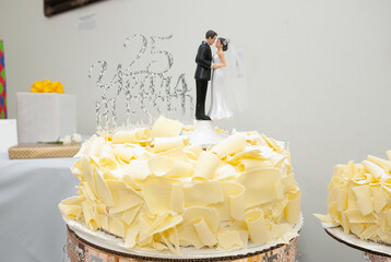 25 year wedding anniversary topper with bride and groom on top of a white cake with shaved with...