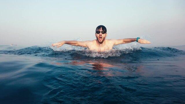 Giovane ragazzo nuota a delfino nel mare