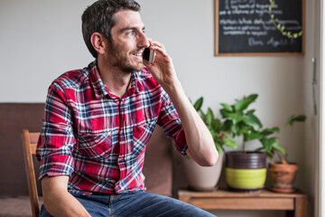 Man sat on chair having fun discussion on cellphone