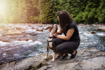 White Caucasian Adult Woman hiking with Boxer Dog in the Canadian Nature. Golden Ears Provincial Park, Maple Ridge, Greater Vancouver, British Columbia, Canada.