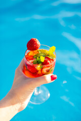 person holding a cocktail in the pool