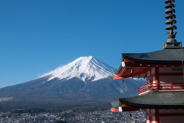 The iconic view of Mount Fuji with the red Chureito pagoda and Fujiyoshida city from Arakurayama sengen park in Yamanashi Prefecture, Japan.