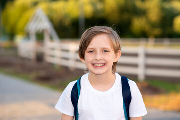 portrait of a happy smiling boy standing at the racetrack on the farm