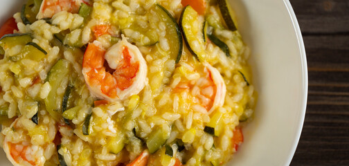 risotto with zucchini and prawns, Italian recipe based on rice and seafood and vegetables, top view dish seen from above