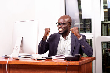 happy business man looking at laptop in office.