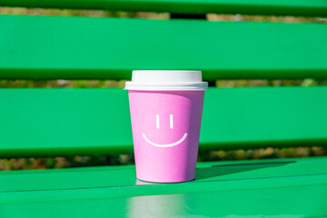 concept of good mood and positive with smiley face on a cup of disposable coffee