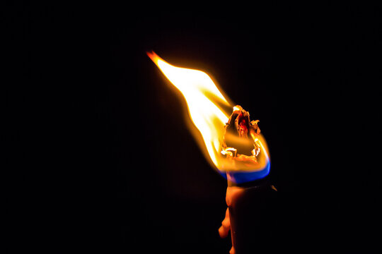 Eine Flamme an einem gl&uuml;hendem St&auml;ngel bei schwarzem Hintergrund