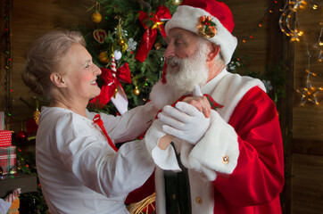 Santa Claus and wife Mrs. Claus near fireplace