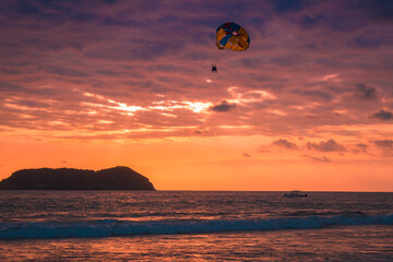 Adult man practices parasailing on a beautiful afternoon on the beach of the tropical Pacific in the Manuel Antonio National Park in Costa Rica