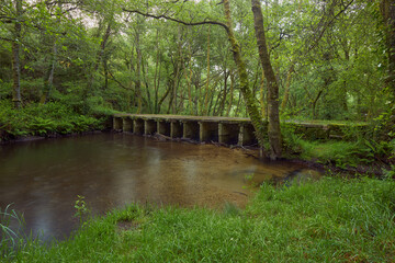 Old stone bridge over the Arenteiro river, in the region of Galicia, Spain.
