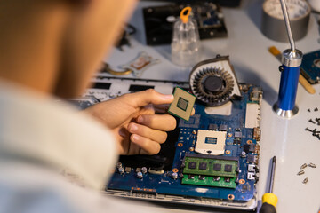 Fototapeta na wymiar technician removing processor from motherboard