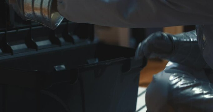 DIY concept. Hands of child in fun silver gloves opening black tool box to take silver tape and scissors and close..