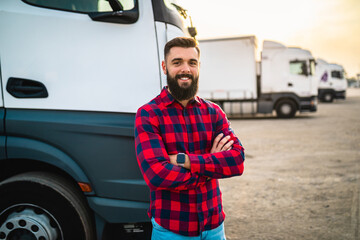 Portrait of young bearded man standing in front of his truck.