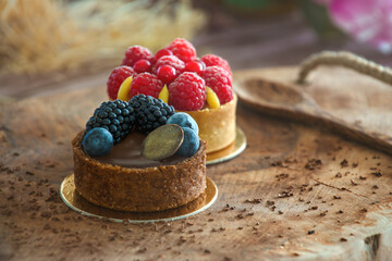 Tertelettes with blackberries, blueberries and raspberries served on a wooden platter.
