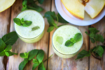 Smoothie melon mint in glasses on a wooden surface. Summer refreshing drink. Detox drink.