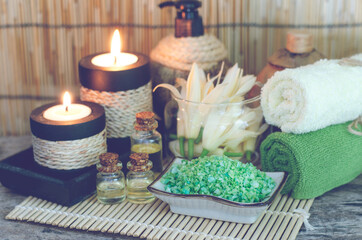 Fototapeta na wymiar Green spa salt with aroma gel and fresh fragrance flower in glass bowl with aroma candle and soft white and green towel in spa shop in soft light tone