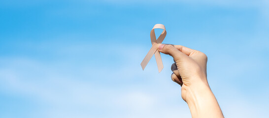 September Uterine Cancer Awareness month, woman hand holding Peach Ribbon for supporting people living and illness. Healthcare and World cancer day concept