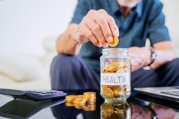 Senior man savings coins in a jar with health word