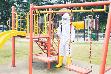 Young man spraying disinfectant in the playground