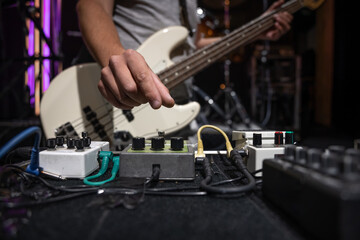 Close-up set of distortion effect pedals for guitar on stage. - obrazy, fototapety, plakaty