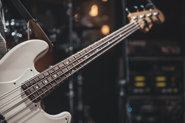 Obraz na płótnie Canvas Close up of bass guitar on blurred dark background copy space.