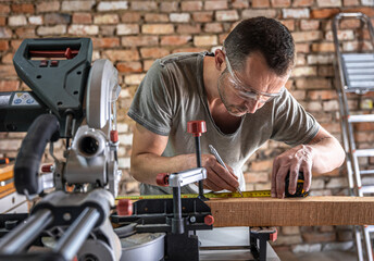 Professional carpenter working with a miter saw.