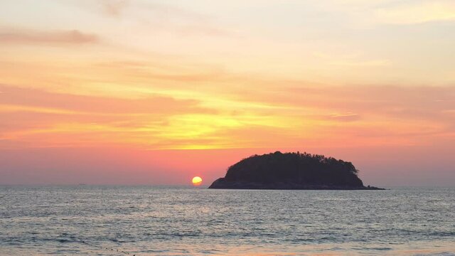 scenery yellow sun going down to the sea..beautiful moving cloud in sweet sky at sunset in Kata beach Phuket Thailand.4k stock footage video in travel concept.