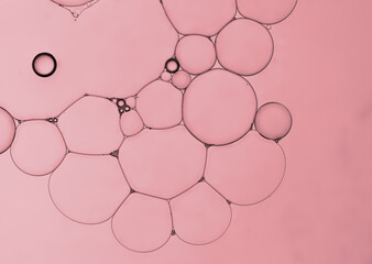 Abstract pink gradient of oil droplets on water created an art image and pattern background.