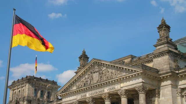 Reichstag Bundestag Berlin Deutschland Germany with german flag on a sunny day summer sky medium shot colorful