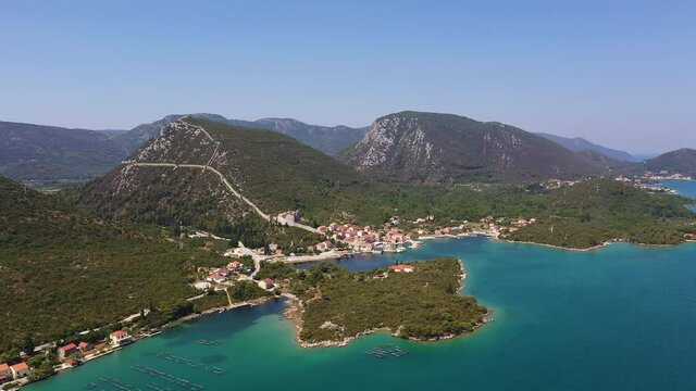 Aerial drone footage of the Mali Ston medieval old town, famous for its very long fortified wall, in Croatia on a sunny summer day