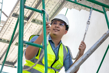 During work at a height, a construction worker wears a safety harness belt. on a background of a...
