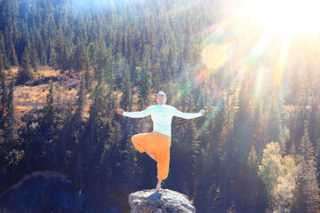 buddhism meditation travel, man doing yoga in traditional yellow pants in nature