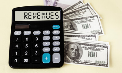 Calculator with the word REVENUES on display with dollars on a white background.
