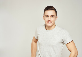 Cheerful man in light t-shirt cropped view isolated background studio