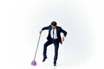 Fototapeta premium business man in a suit with a mop in his hands providing services cleaning floors
