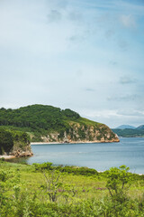 Fototapeta premium summer azure clear sea panorama. shallow transparent sea with reefs, rocks and green hills around. Japan sea. Primorsky Krai in Russia, Putyatina Island