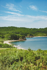 summer azure clear sea panorama. shallow transparent sea with reefs, rocks and green hills around. Japan sea. Primorsky Krai in Russia, Putyatina Island