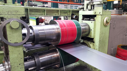 Rolled steel sheet coil slitting process in factory, slitting knife stand - obrazy, fototapety, plakaty