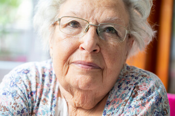 Portrait of a beautiful old woman with gray hair and glasses 