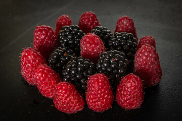 Summer berries. Ripe raspberries and blackberries. Healthy eating. Healthy foods. Juicy berries for dessert. Background for cafe and restaurant. Delicious still life. Seasonal products. Red and black.