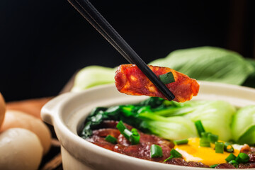 Cantonese style cooking of claypot rice with waxed meats