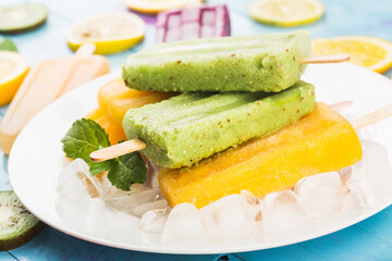 Healthy Whole Fruit Popsicles with Berries Kiwi watermelon cantaloupe on wooden vintage table
