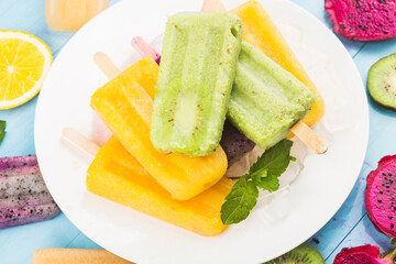 Healthy Whole Fruit Popsicles with Berries Kiwi watermelon cantaloupe on wooden vintage table
