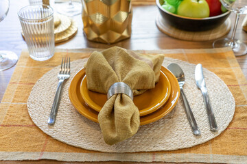 Napkins, tableware and cutlery set the table for dinner at home.