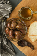 Olives, olive oil and bread on wooden rustic table.