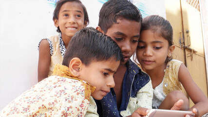 Group of Indian children looking at the phone