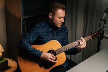 Talaented guitarist singer man emotionally singing into condenser microphone and playing acoustic...